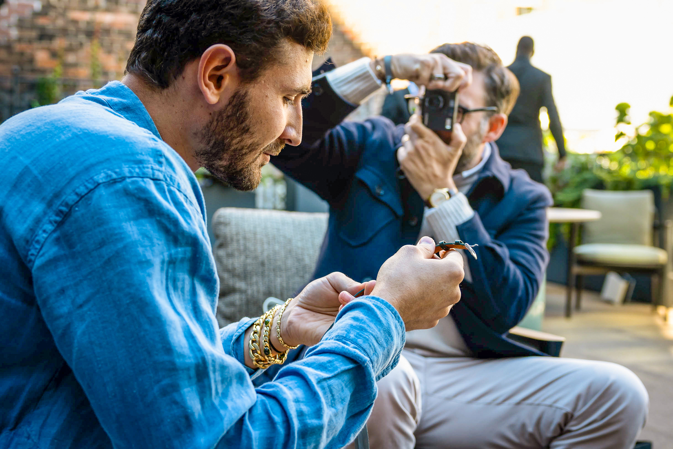 Alessandro Fanciulli gets his photo taken by Hodinkee President Ben Clymer while both sit outside and Alessandro holds and looks down at a watch