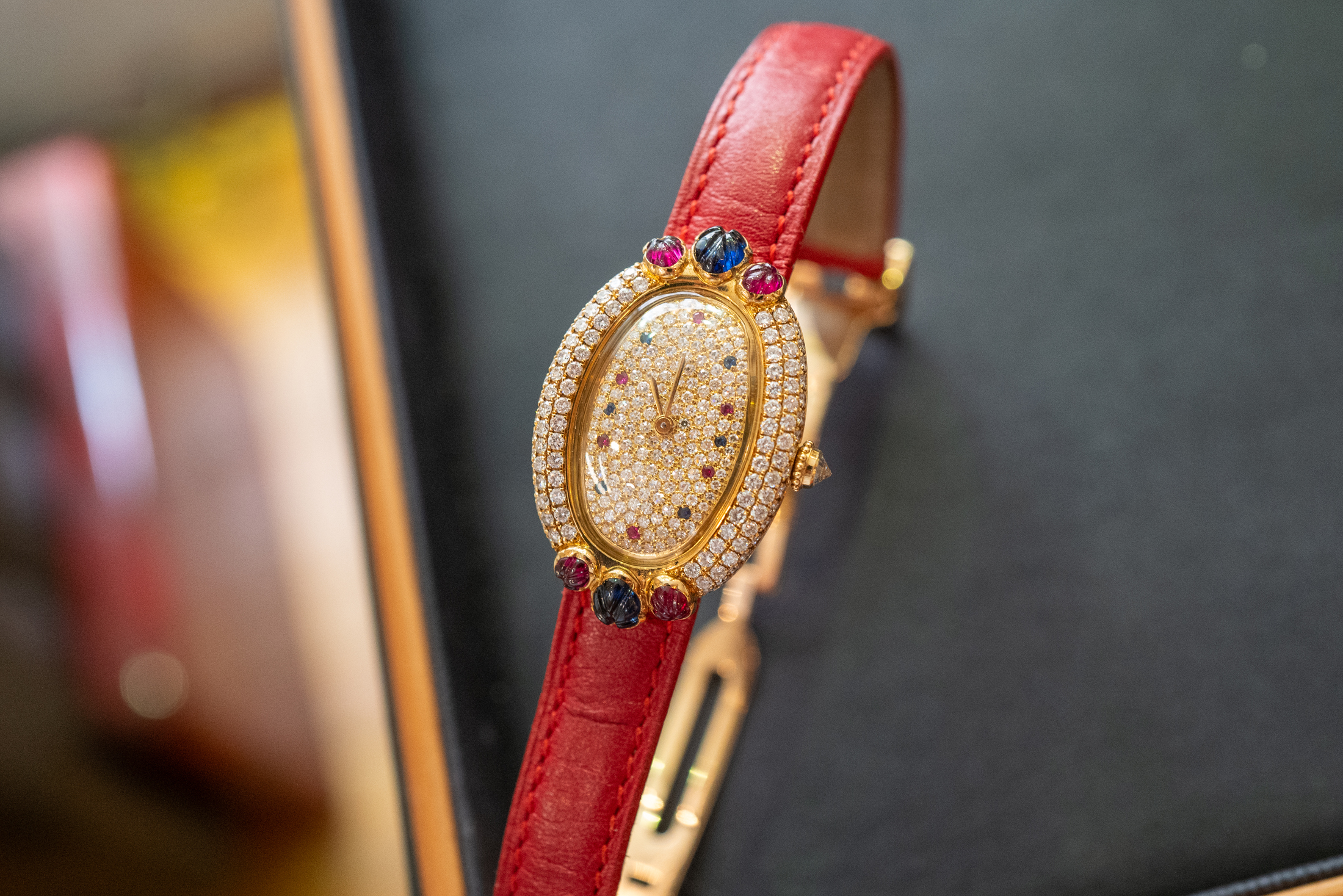 Cartier Baignoire with multi-colored jewels and a red leather strap