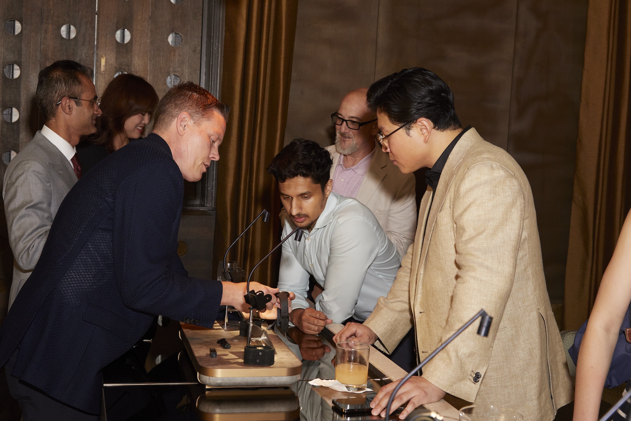 Three men looking at watches