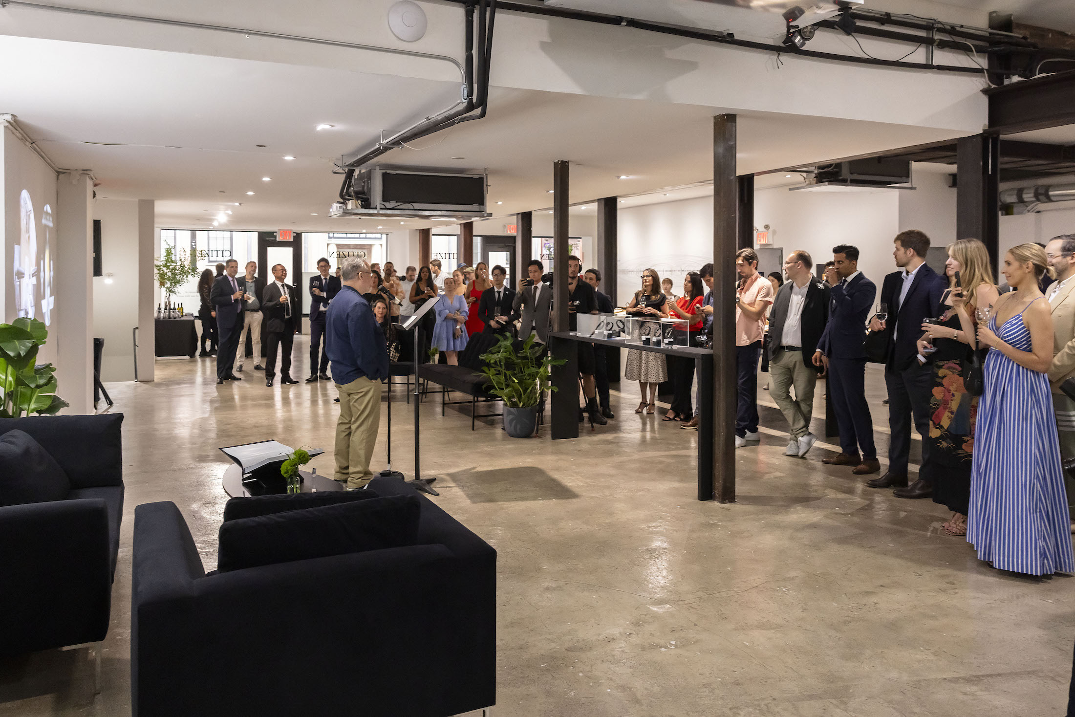 A group of people listening to a man talk at a podium