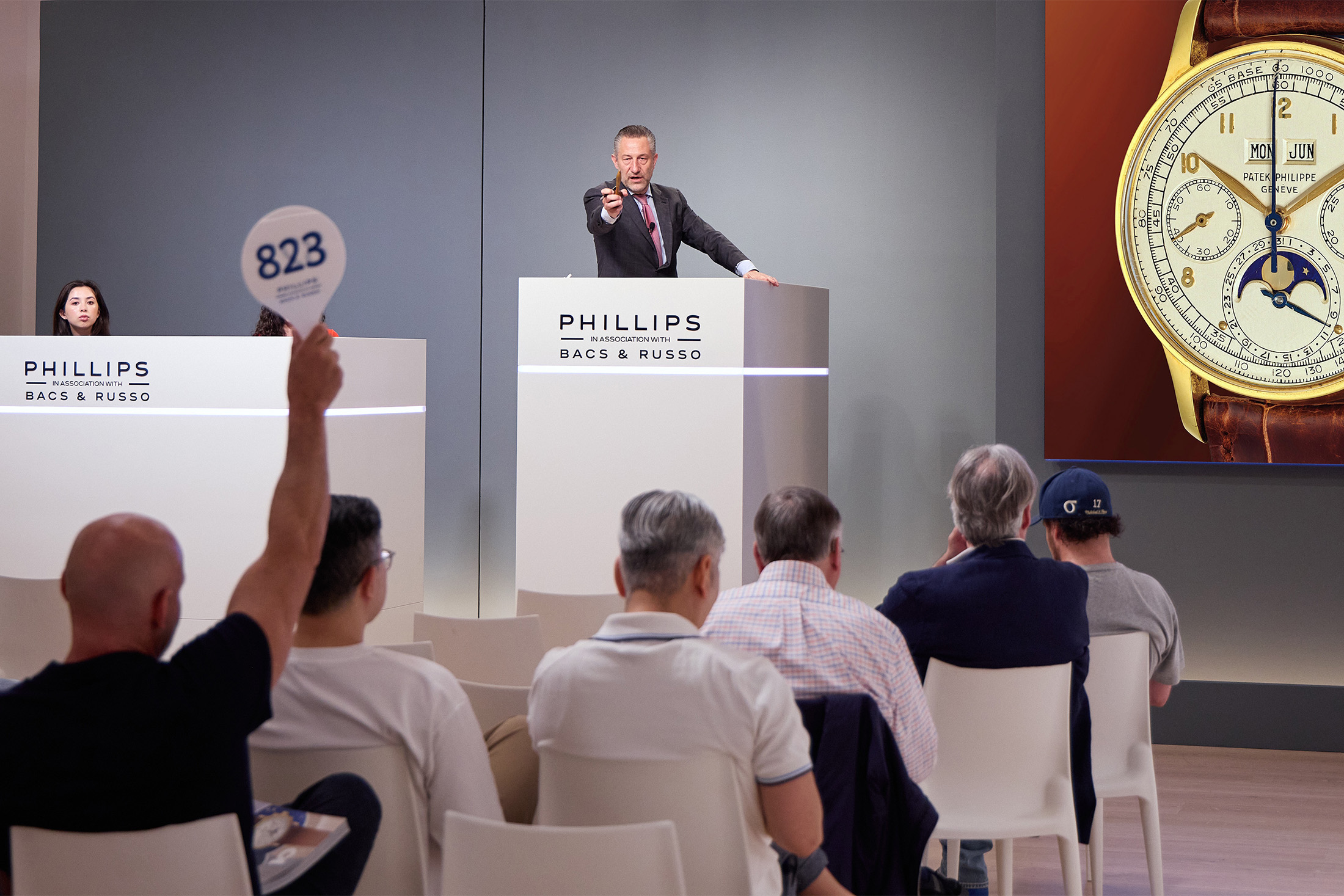 Aurel Bacs at the rostrum and a bidder bidding at Phillips