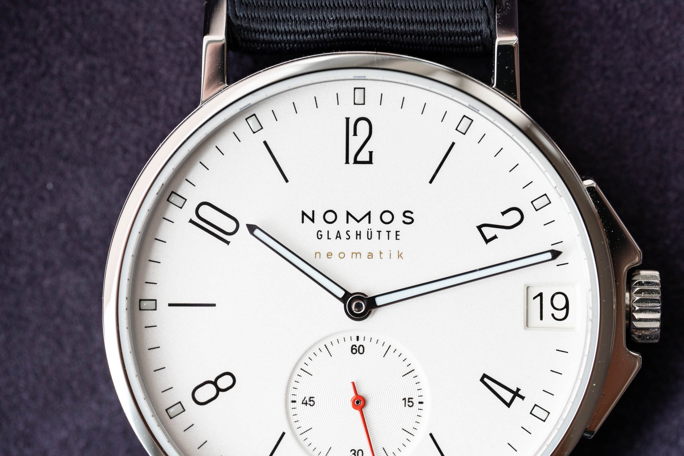 Nomos logo on dial closeup