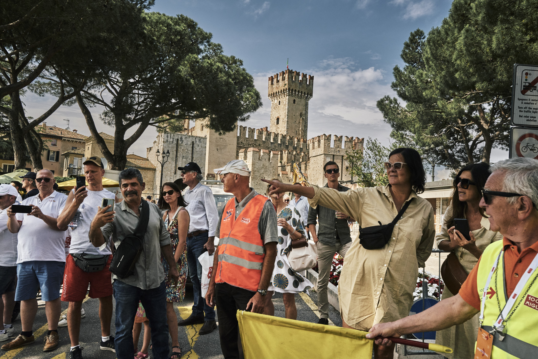 A crowd gathering to watch and point directions.