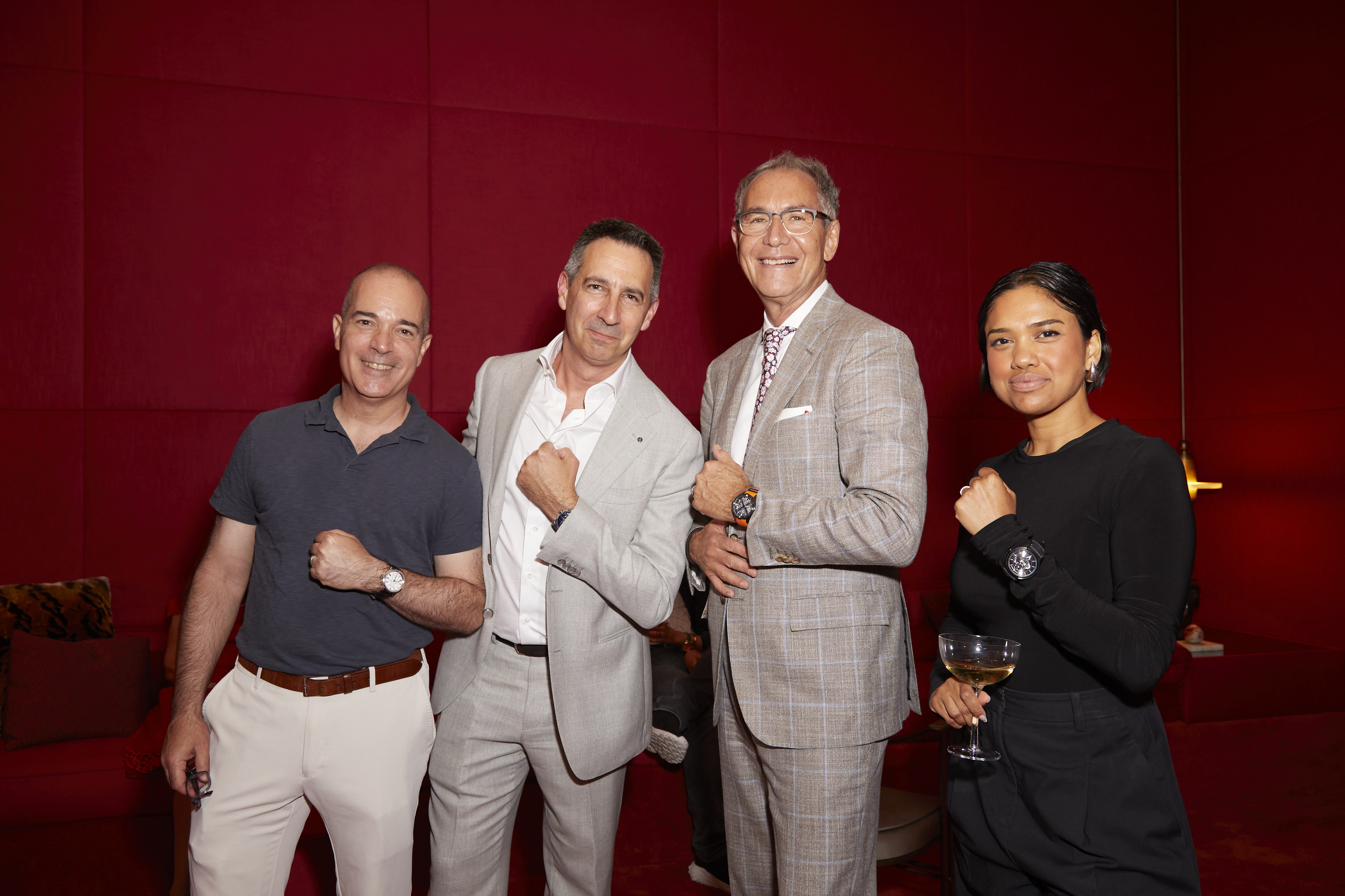 four people pose for a photo and show off their watches